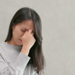 woman pinching bridge of her nose